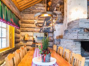 a dining room with a wooden table and a chandelier at Holiday Home Terakka by Interhome in Sirkka