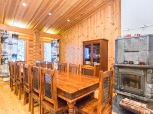 uma sala de jantar com uma mesa de madeira e uma lareira em Holiday Home Karhunpesä a by Interhome em Kotila