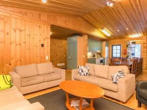 ein Wohnzimmer mit zwei Sofas und einem Tisch in der Unterkunft Holiday Home Karhunpesä a by Interhome in Kotila
