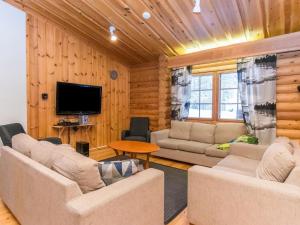 a living room with two couches and a television at Holiday Home Karhunpesä a by Interhome in Kotila