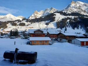 a village in the snow with mountains in the background at Apartment Lärchehuus by Interhome in Adelboden