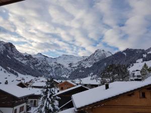 a town with snow covered mountains in the background at Apartment Lärchehuus by Interhome in Adelboden