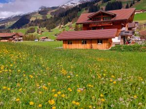 a field of flowers in front of a wooden house at Apartment Lärchehuus by Interhome in Adelboden