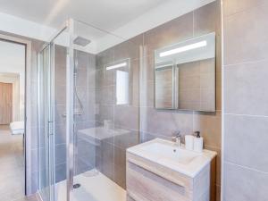 een badkamer met een douche, een wastafel en een spiegel bij Apartment Paesu Pimpan by Interhome in Porto-Vecchio