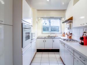 a white kitchen with a sink and a window at Apartment La Baie by Interhome in Dinard +13 photos