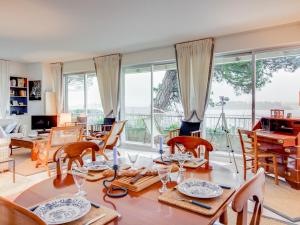 uma sala de estar com uma mesa, cadeiras e janelas em Apartment La Baie by Interhome em Dinard