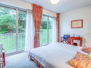 a bedroom with a bed and a large window at Apartment La Baie by Interhome in Dinard