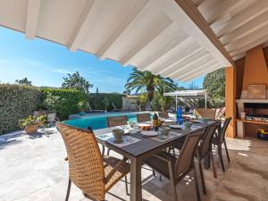a patio with a table and chairs and a pool at Villa Clos des collines by Interhome in Gassin