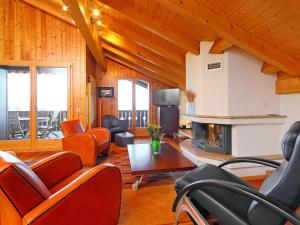 a living room with leather chairs and a fireplace at Apartment Sunset B 11 by Interhome in Villars-sur-Ollon