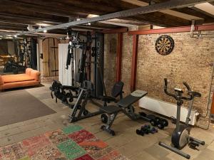 a gym with several exercise equipment in a brick wall at Top-notch apartment along canal in historic centre in Amsterdam