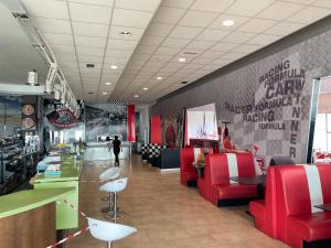 a restaurant with red chairs and a person in the background at Area 507 in Outeiro de Rei