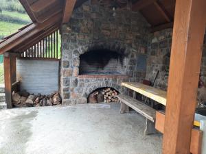 a stone fireplace with a bench in front of it at Vineyard cottage Klobčar in Semič