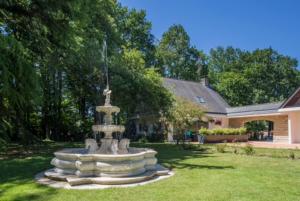 a fountain in the yard of a house at La Clotière in La Guerche-de-Bretagne