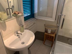 y baño blanco con lavabo y ducha. en Agriostello Riparo en Anzio