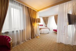 una habitación de hotel con 1 cama, cortinas y 1 dormitorio en Le Sart Resort, en Vnukovo