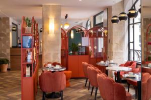 a restaurant with orange chairs and tables in a room at Hôtel Regina Opéra Grands Boulevards in Paris