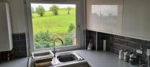 a kitchen counter with a sink and a window at Espedair Apartment in Paisley