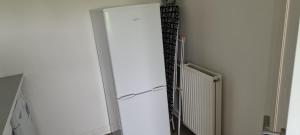 um frigorífico branco com a porta aberta num quarto em Espedair Apartment em Paisley