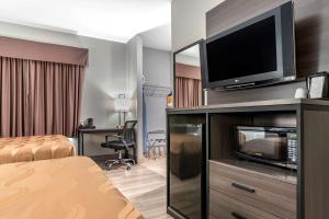 a hotel room with a flat screen tv on a entertainment center at Quality Inn & Suites Demopolis in Demopolis