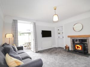 a living room with a couch and a fireplace at Garden House - Brodie Castle in Forres