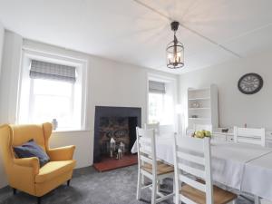 a dining room with a white table and a yellow chair at Garden House - Brodie Castle in Forres