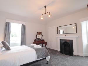 a bedroom with a bed and a fireplace at Garden House - Brodie Castle in Forres