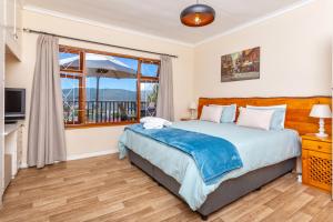 a bedroom with a large bed and a window at Prospect Cottage in Knysna