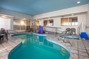 una piscina en una habitación de hotel con sillas y mesa en Comfort Inn Flagstaff Lucky Lane I-40, en Flagstaff