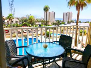 una mesa y sillas en un balcón con piscina en Apartamento Playa de las Américas II, en Playa de las Américas