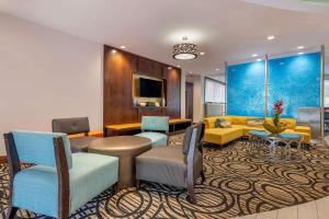 a living room filled with furniture and a tv at Comfort Suites Fort Lauderdale Airport South & Cruise Port in Dania Beach