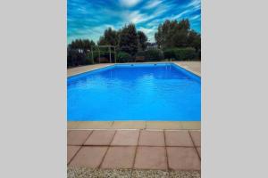uma piscina com água azul num quintal em Maison de vacances dans résidence avec piscine em Sarzeau