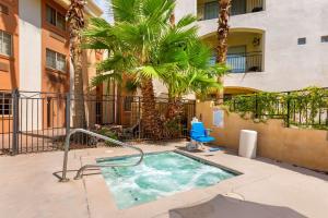 a hot tub in the courtyard of a building with palm trees at Comfort Inn & Suites North Glendale and Peoria in Glendale