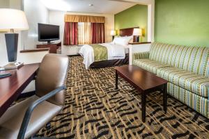 Quality Inn & Suites في دانفيل: غرفة في الفندق مع أريكة وسرير