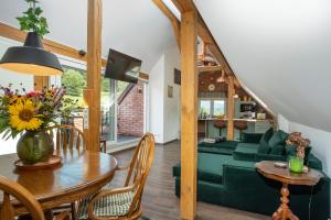 a living room with a green couch and a table at Pine Cone Loft on Baden-Baden's Panorama Trail in Baden-Baden