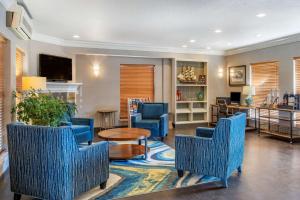 Elizabeth Oceanfront Suites, Ascend Hotel Collection في نيوبورت: غرفة معيشة مع كراسي زرقاء وطاولة
