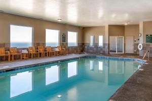 una piscina in un hotel con sedie e tavoli di Elizabeth Oceanfront Suites, Ascend Hotel Collection a Newport