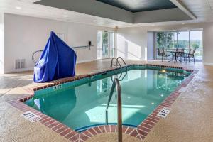 una piscina con sombrilla azul en una habitación en Comfort Suites Anderson-Clemson, en Anderson
