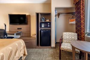 a hotel room with a refrigerator and a tv at Quality Inn in Sanford