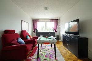 a living room with a red couch and a table at Ferienwohnung Schuur - Harz in Hasselfelde
