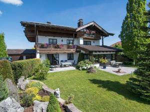 uma casa grande com um quintal com paisagismo em Ferienwohnungen Blos em Grassau