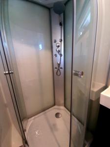 eine Dusche mit Glastür im Bad in der Unterkunft Tuinhuis Duinroos Deluxe in Callantsoog