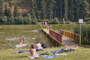 a group of people in the water near a dock at CAMP Dolce in Trutnov