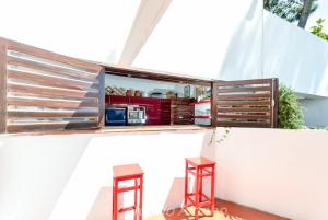 a kitchen with two stools next to a white wall at Cerca do Altinho in Vila Nova de Milfontes