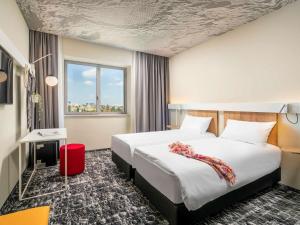 a hotel room with a large bed and a window at ibis Bucharest Politehnica in Bucharest