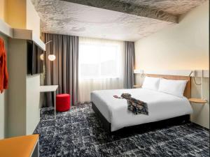 a hotel room with a white bed and a window at ibis Bucharest Politehnica in Bucharest