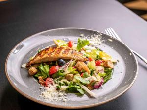 a plate of food with a salad on a table at ibis Bucharest Politehnica in Bucharest