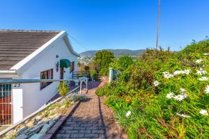 una casa con un camino que conduce a un edificio en Prospect Cottage, en Knysna