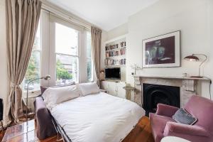 een woonkamer met een bed en een open haard bij Veeve - Vintage Hollywood in Notting Hill in Londen