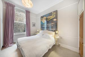 een slaapkamer met een bed en een poster aan de muur bij Veeve - Vintage Hollywood in Notting Hill in Londen