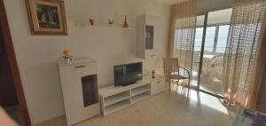 a living room with a tv on a white cabinet at COBLANCA 20 - Fincas Arena in Benidorm